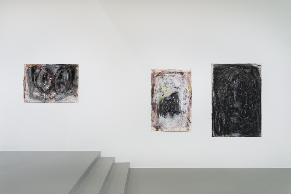 Installation view of three drawings across a wall and three stairs
