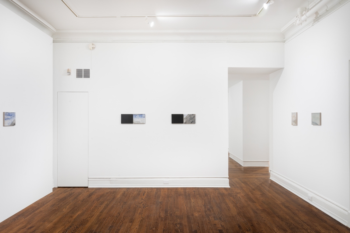 Installation view of series of small works in line across three walls