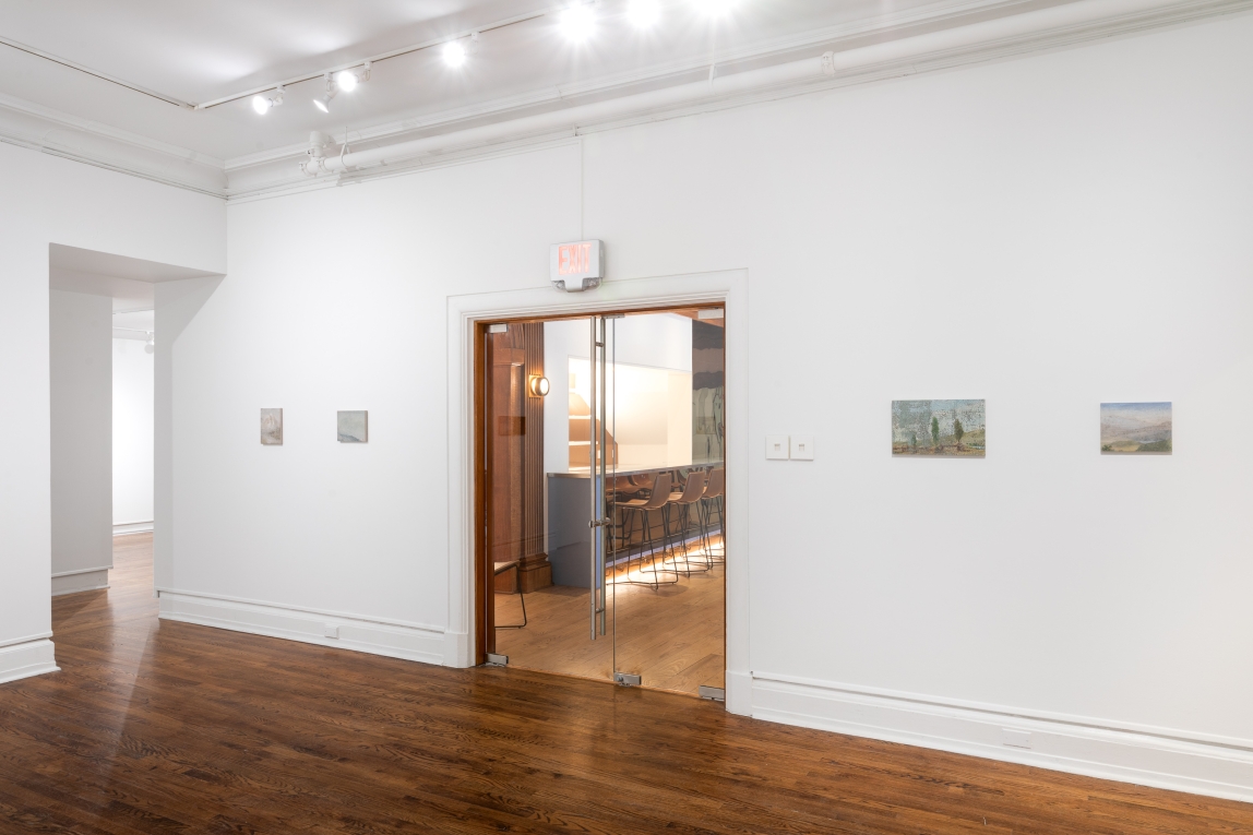 Installation view of four small works arranged in line on wall, interrupted by glass doors