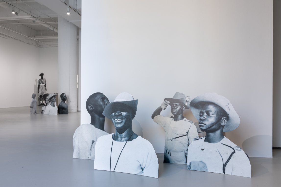 Installation view of cardboard cutouts of photos of black soldiers