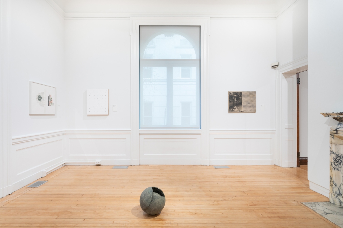 Installation image of Gallery A with three works hanging on two walls and sculpture on floor