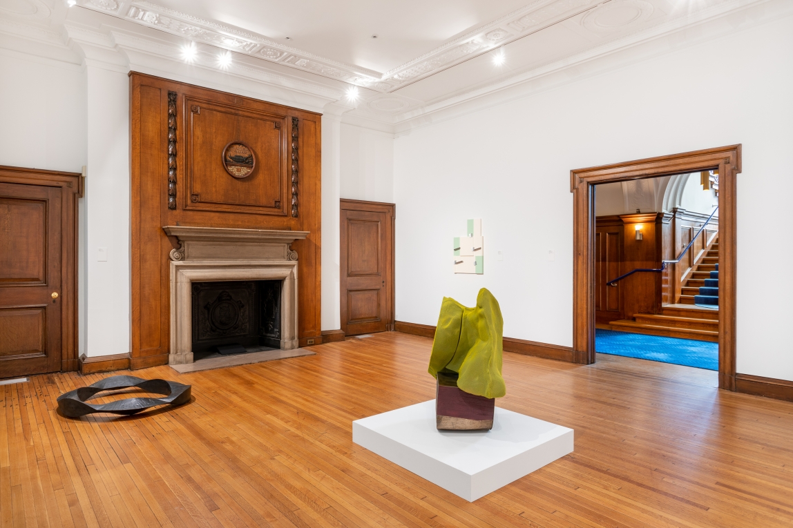 Installation view of Gallery B with two sculptures on ground and another work hanging on far wall