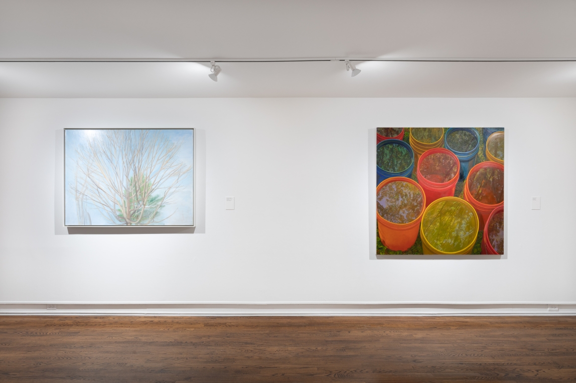 Installation view of two paintings, one of trees, the other of trees reflected in buckets of water