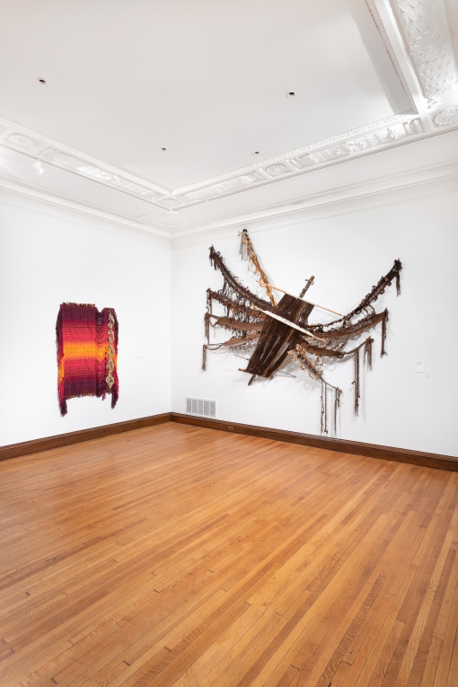 Installation view of two fiber artworks hanging on adjoining walls