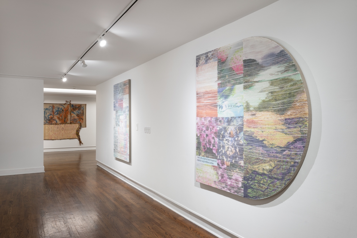 Installation view of woven artworks, two on wall in foreground, part of one visible in background