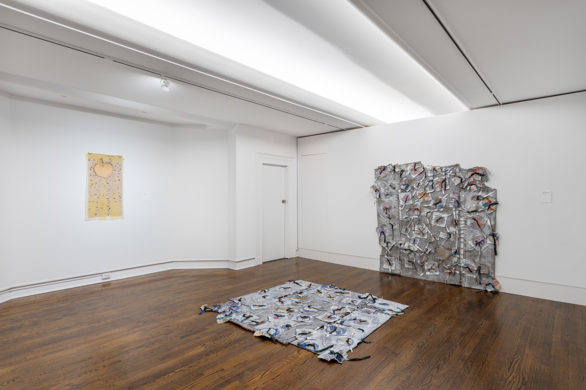 Installation view of there fiber artwork pieces, two hanging on opposing walls and one laid on the floor
