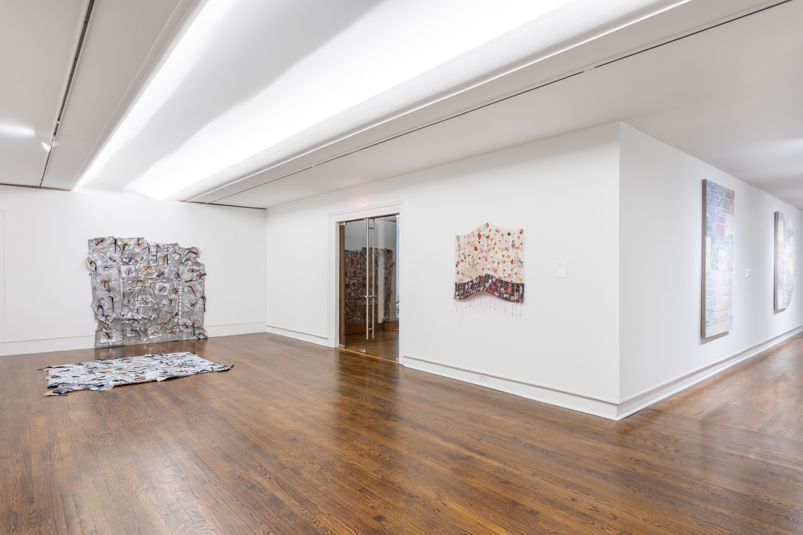 Installation view of fiber artworks displayed across two gallery spaces