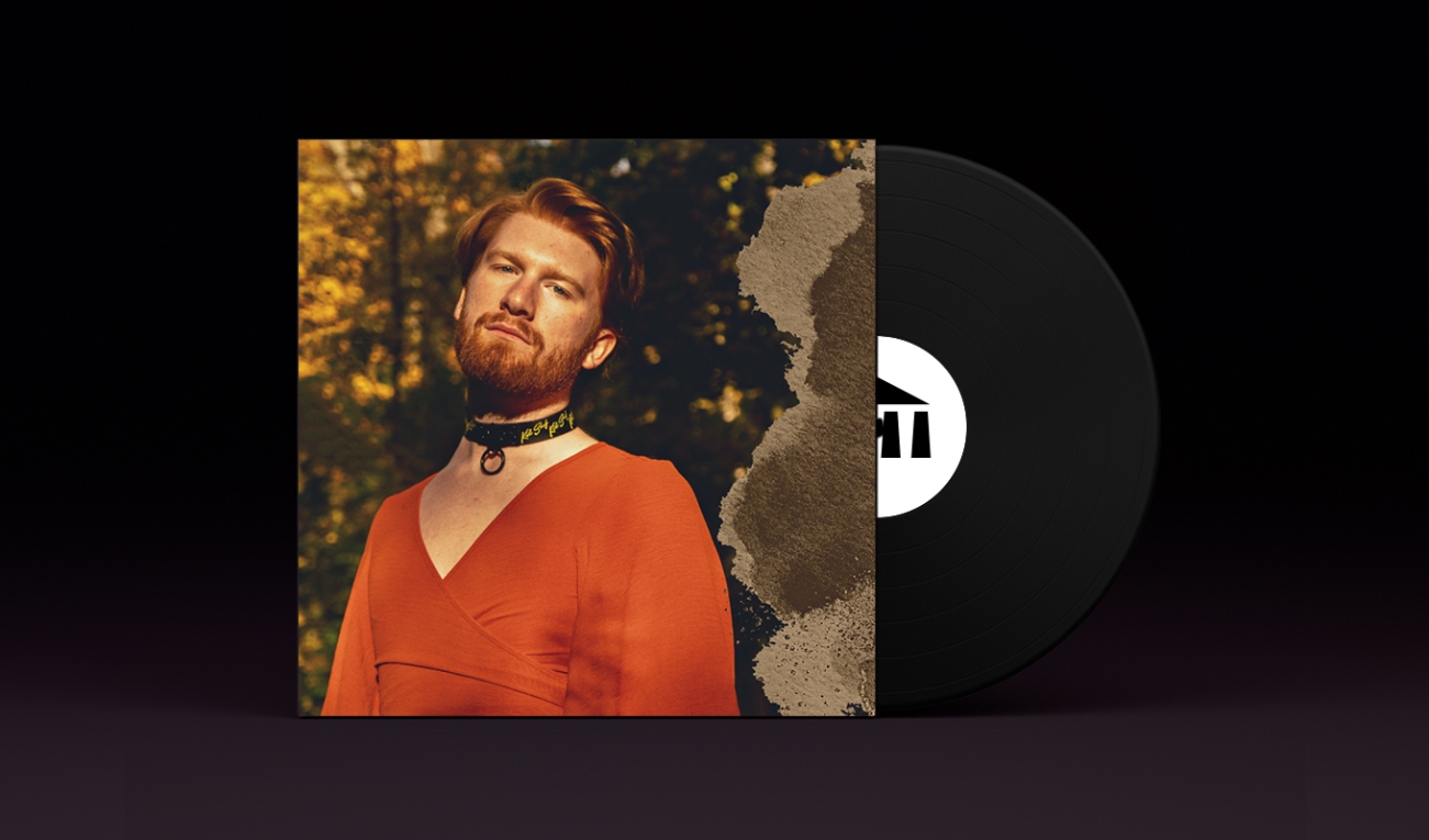 A stylized vinyl record album cover with a black record stamped with the UArts logo poking out. On the sleeve is student aidan reeves in a choker and orange tunic in a forest bathed in golden light.  