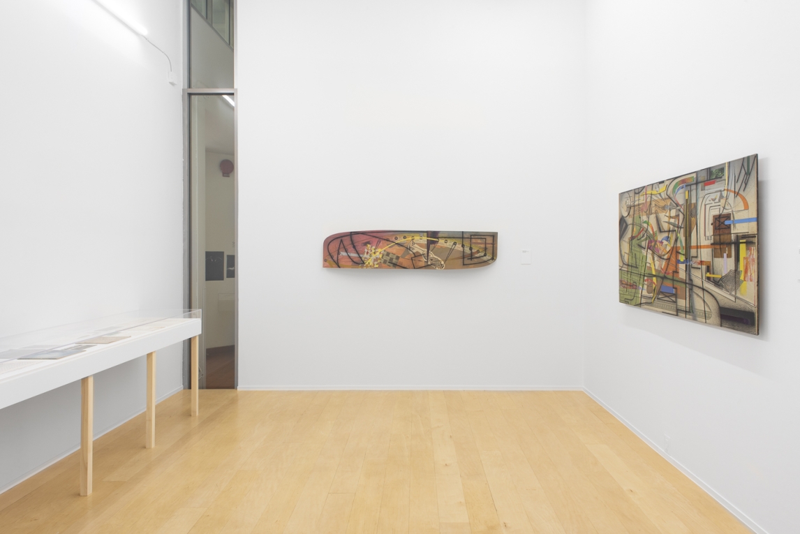 Installation image of back gallery with a painted wavy board, another geometric painting and a display case