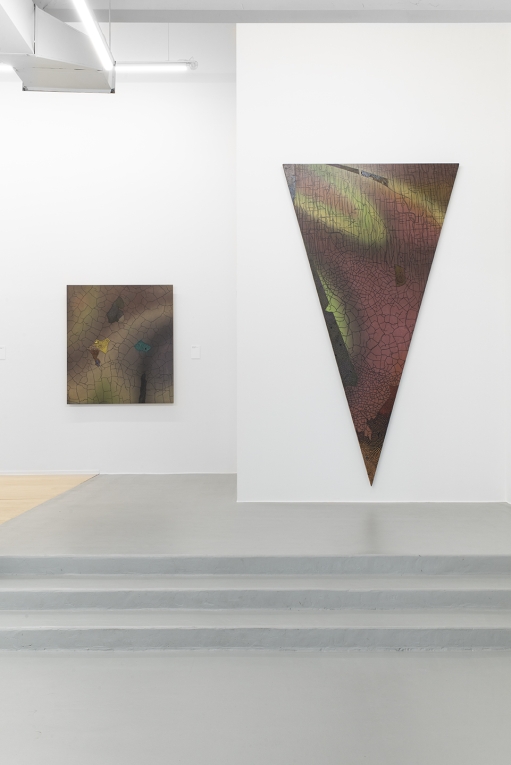 Installation image of large triangle panting, pointed down, in foreground and another painting in background