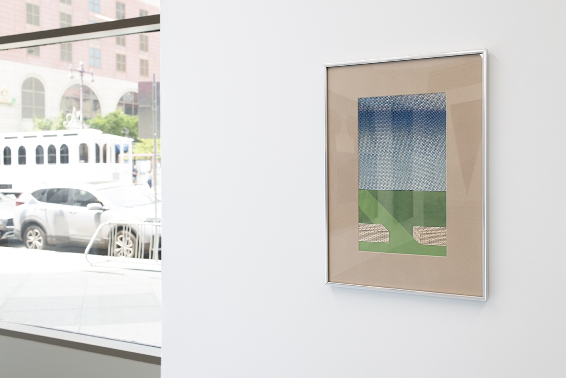 Installation image of blue and green and white work in foreground and a window in background