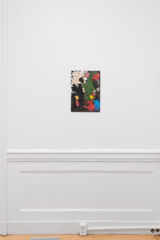 Installation view of a paint-covered palette hanging on a wall