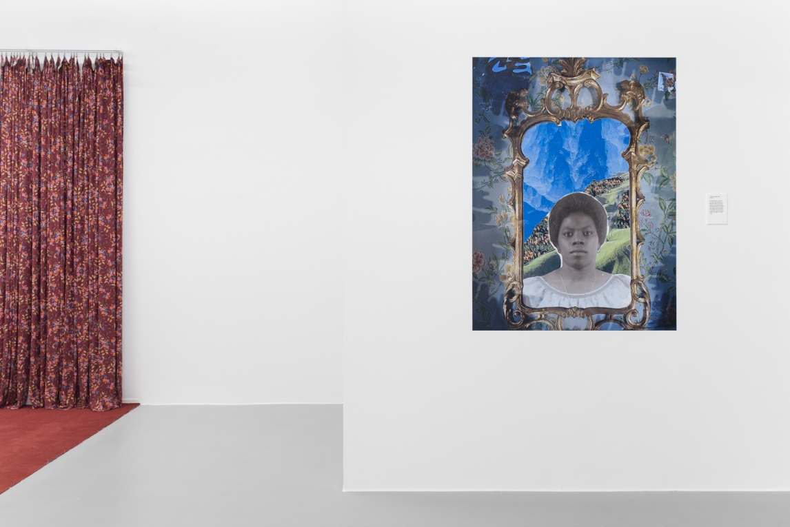Installation view of a vinyl image of a Black woman framed by a gold mirror