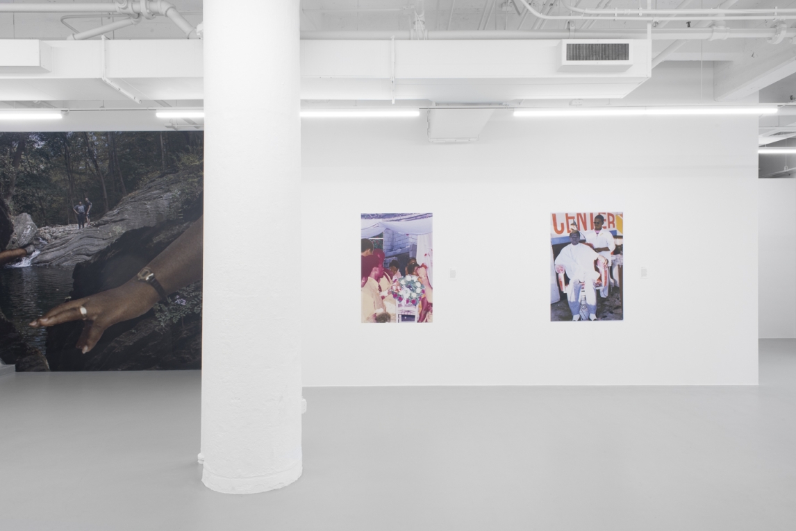 Installation view of gallery walls with large vinyl mural to left and two vinyl images on white wall to right
