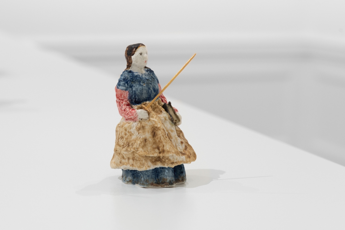 Small sculptural figure of woman with sword