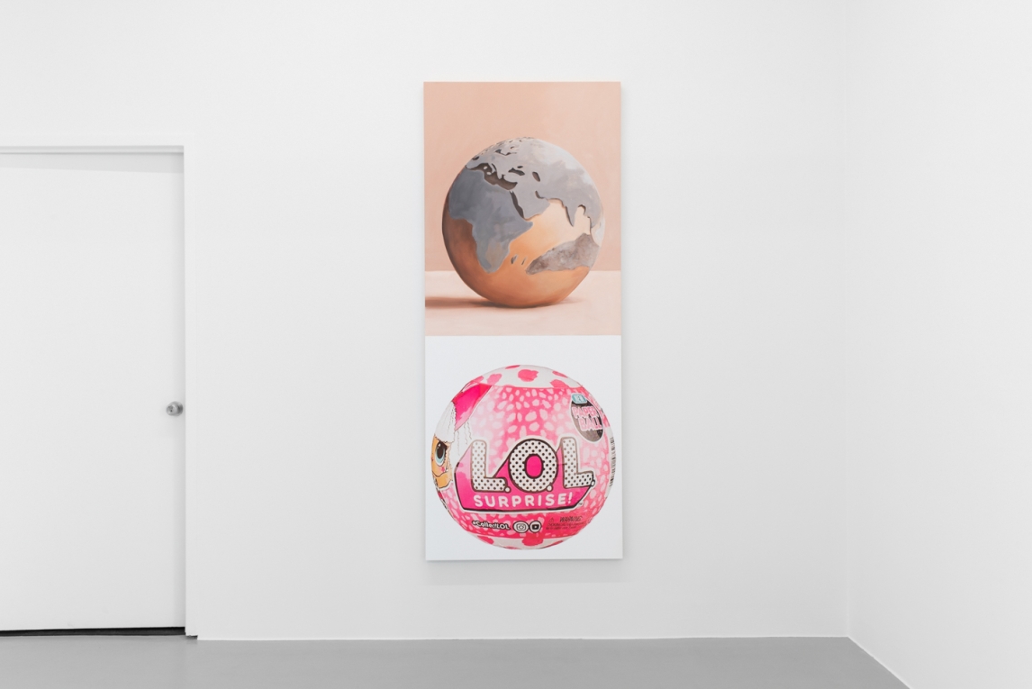 Artwork hanging on white wall depicting a globe on one panel and a round LOL toy on the other