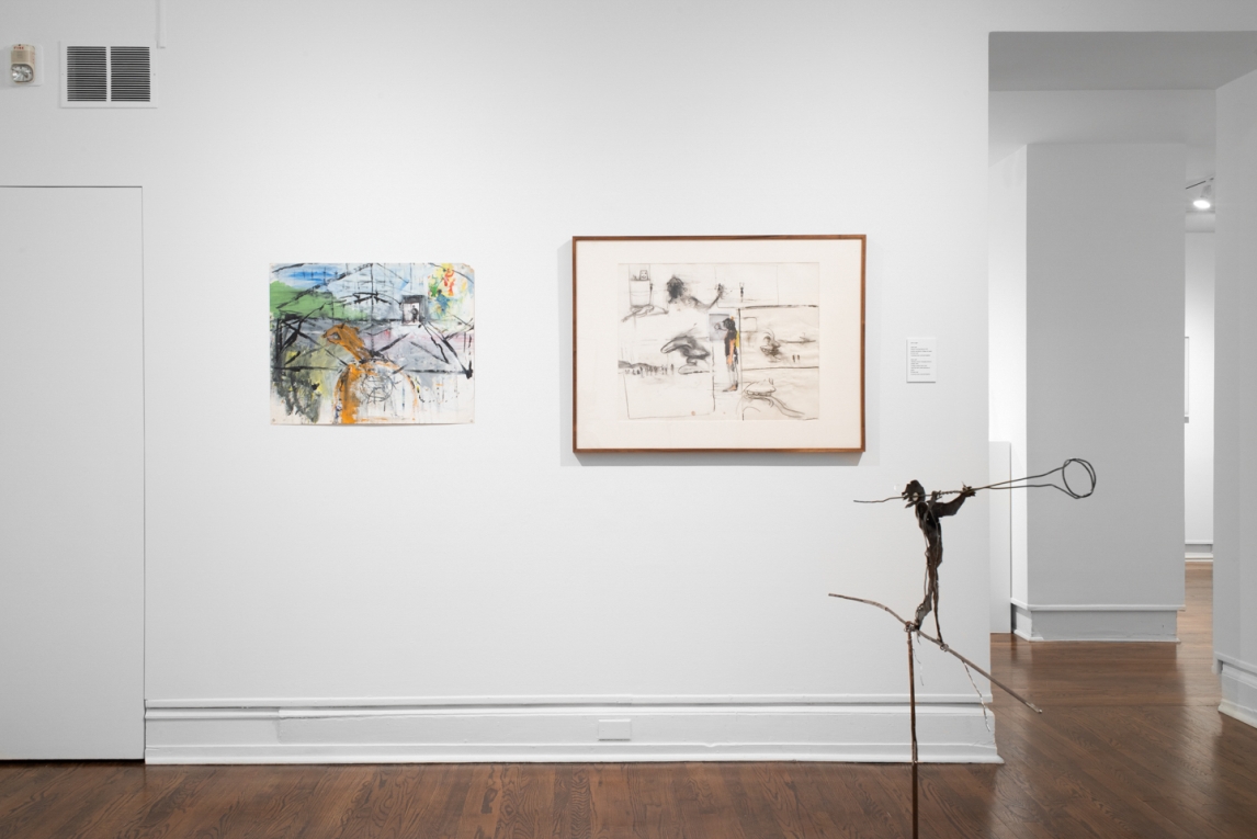 Two works hanging next to one another on. a wall with a metal sculpture in foreground