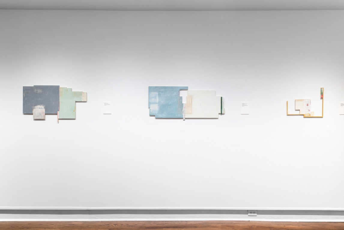 Three mixed media artworks displayed in a row on white wall