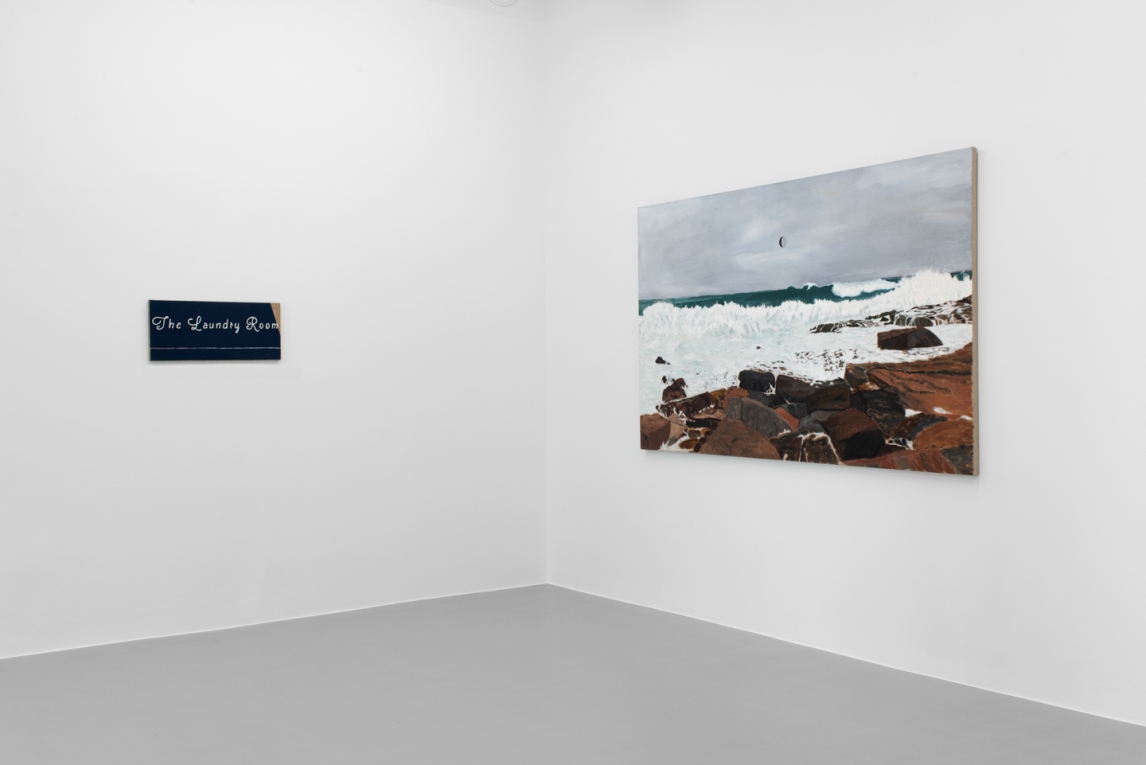 Installation image of large painting of coast and smaller painting with words