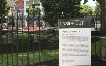 A black and white sign that describes the Inside Out project in Trenton and the full text is in the caption below