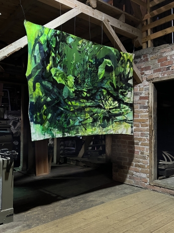 A green and black nature scene that depicts bats and the canvas is hanging in a room with brick walls