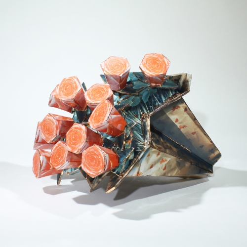 A ceramic bouquet that looks like paper with orange blossoms and a metallic wrap around the stems