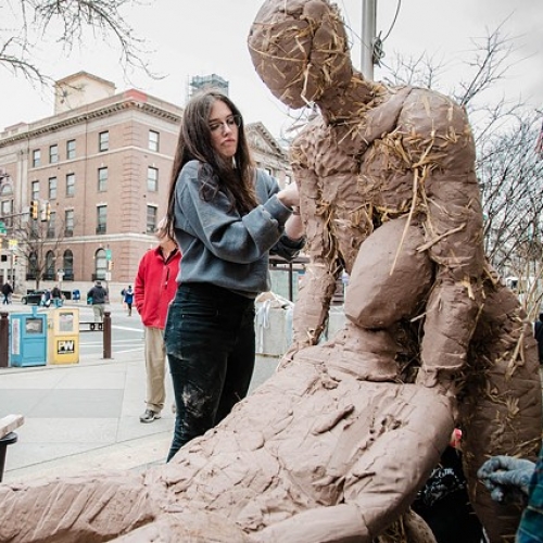 Ciara Wright sculpting a clay figure on Broad Street in Philadelphia