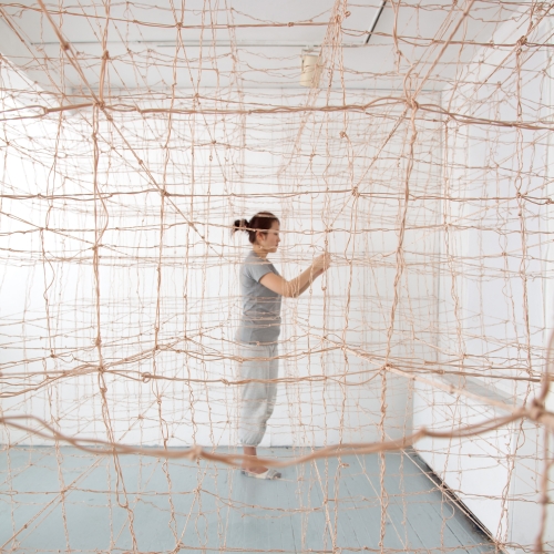 Fibers senior Qiang Gong creating room-wide netting installation 