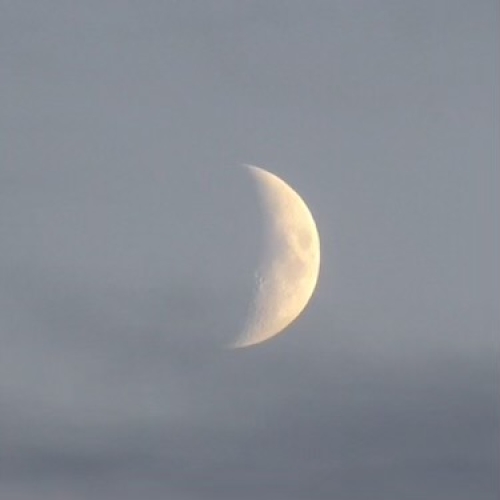 A photo of a half moon in the sky