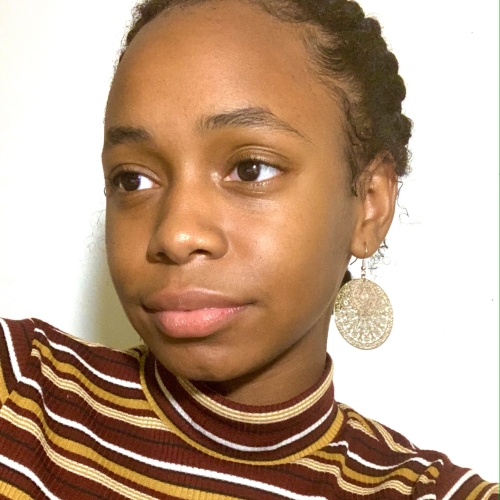 picture of keshawna logan wearing a stripped turtleneck and with a large dangling circular gold earring