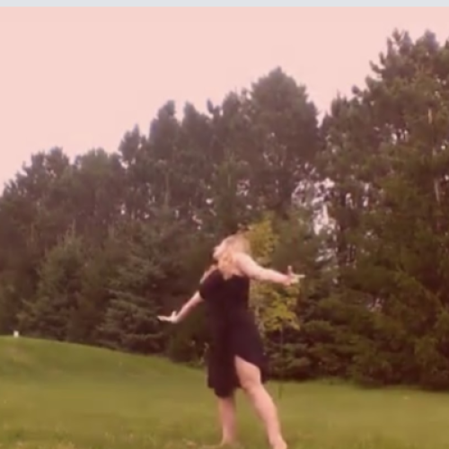 A photo of Marcella Schneider dancing in a green field