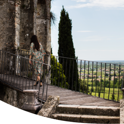 A woman walking up stairs among Italian hills.