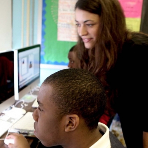 Michele McKeone assisting a student at a computer
