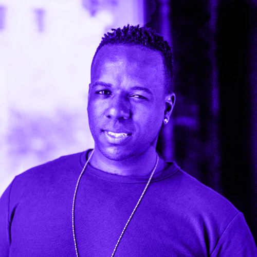 headshot of tommie waheed evans overlaid with violet. tommiee is wearing a simple crew neck t shirt and a long thin gold chain and is looking at the camera with a series look. 