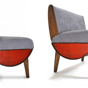 Two grey couches with oil drums as the bottom and wood as the legs 