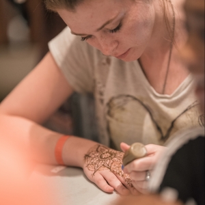 A student concentrates on creating henna art during Henna Night