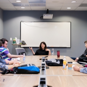Students and faculty sit around a conference room table and learn from alum Jenn Wexler BFA '08 (WFTV). 