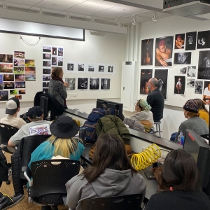 A group of students and faculty review students' work during critiques.