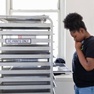 A student inspects their work before drying it on the RC Print rack