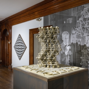 Invisible City Exhibition, 2nd Floor Landing: angled perspective of the landing, with the model of Anne Tyng's and Louis Kahn's City tower in the right foreground and a geometric painting in the left background