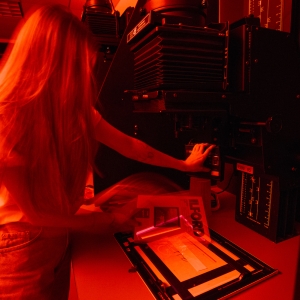 A student works on developing photos in the dark room.