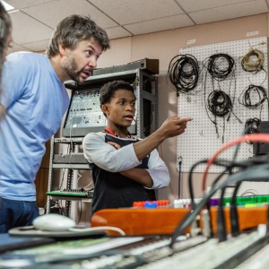 A teacher and student discuss audio production in the studio