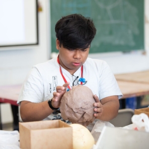 A Sculpture student shapes a head out of clay