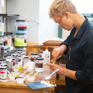 An Art student mixes paint in the classroom
