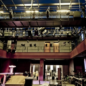 interior of caplan studio theater during event setup. the lights above the catwalks are on. 